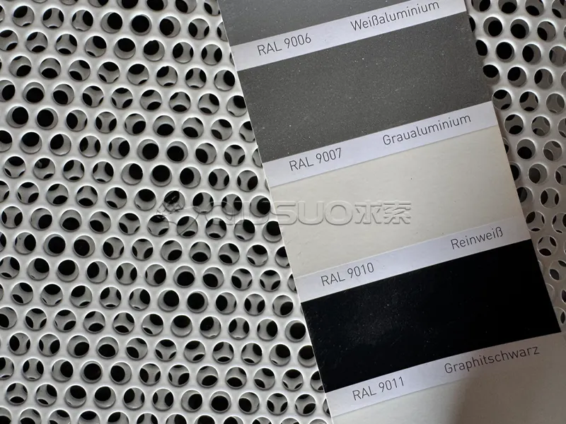 The color of the finished aluminum perforated sheet is being compared using a color chart.