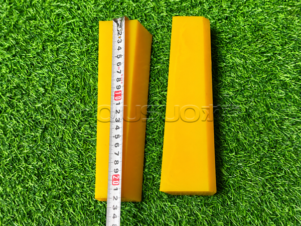 A worker is checking the length of a polyurethane wedge.