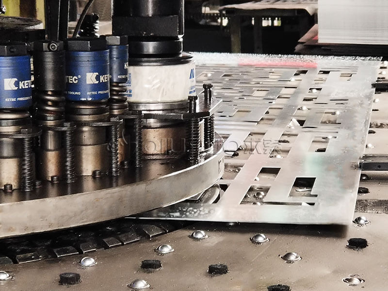 A CNC turret punching machine is punching rectangle holes on a aluminum plate.