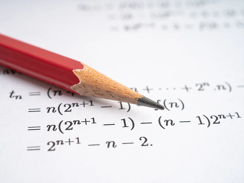 Keskin bir kırmızı kalem, hesaplama formülleri ile dolu taslak kağıda yerleştirilir