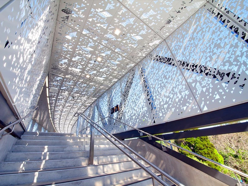 Decorative perforated panel used as a sunshade on the exterior wall at the subway entrance