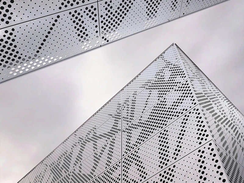 The exterior wall of the office building is decorated with circular decorative perforated panels.