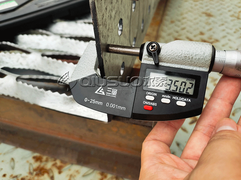 A micrometer is used to check the thickness of grip strut plank grating.