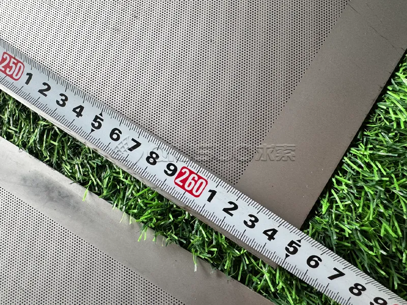 A worker is measuring the length of the laser micro perforated plate.