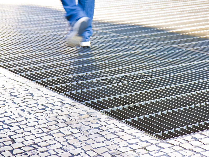 Metal bar grating used as a drainage trench cover on the road