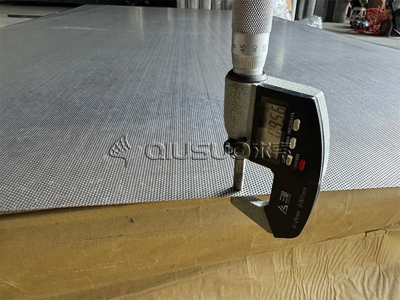 A worker is measuring the thickness of the micro hole perforated metal.