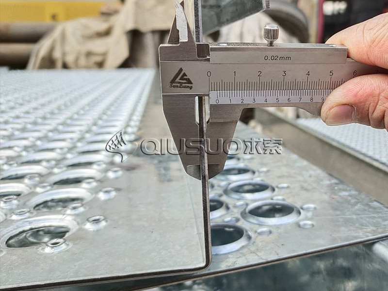 A caliper is used to check the thickness of Perf-O grip safety grating.