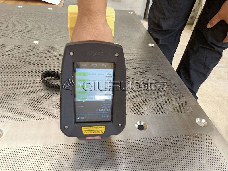 Un trabajador tiene equipo para probar el paso de perforación de placas perforadas PMI.