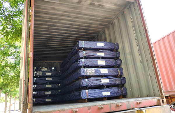 Perforated metal products are packaged with blue waterproof rain cloth for delivery.