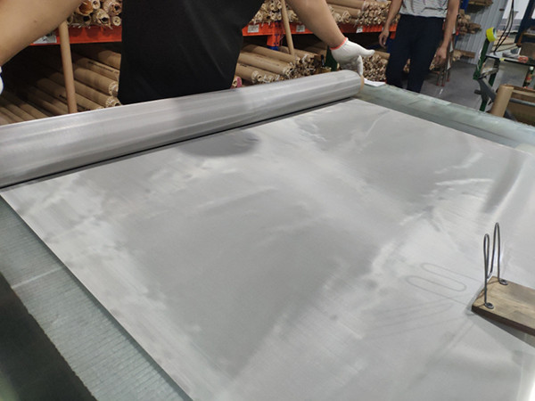 Работник проверяет качество ткани провода нержавеющей стали по-одному