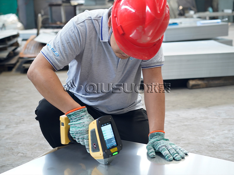 A worker is checking the raw material component of traction tread safety grating.