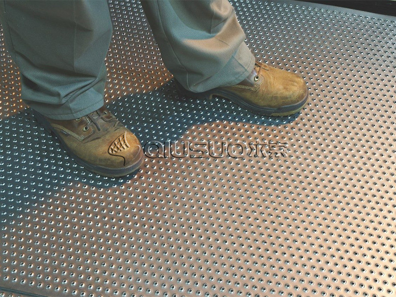 A man is walking on the working platform made of traction tread safety gratings.