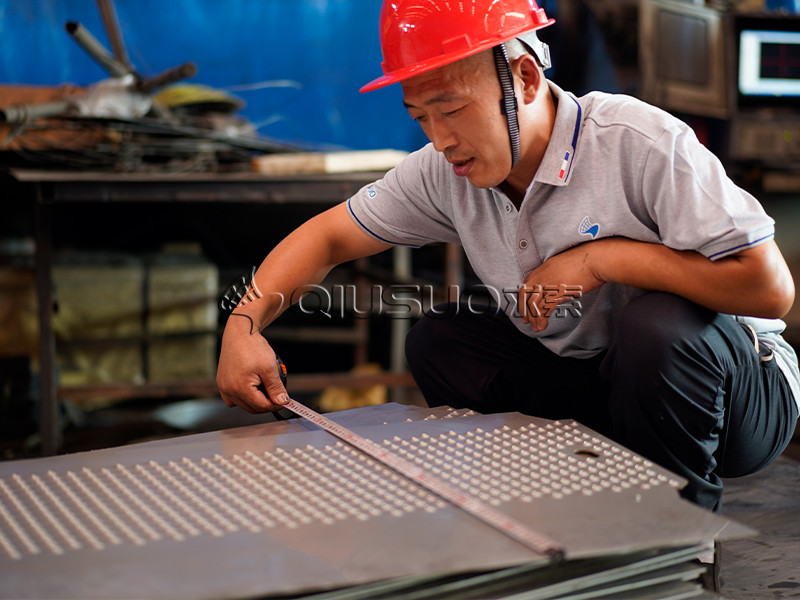 A worker uses a tape for traction tread safety grating width inspection.