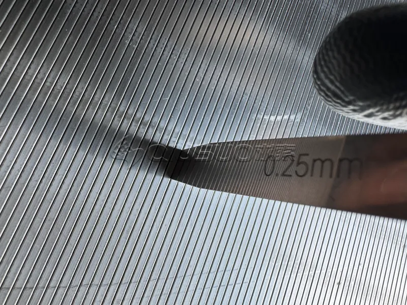 A worker is measuring the slot dimensions of the wedge wire screen panel.